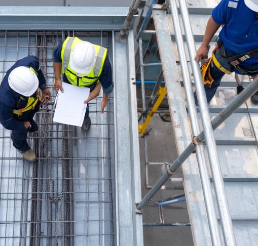 hombres trabajando en la construcci&oacute;n, sobre andamios