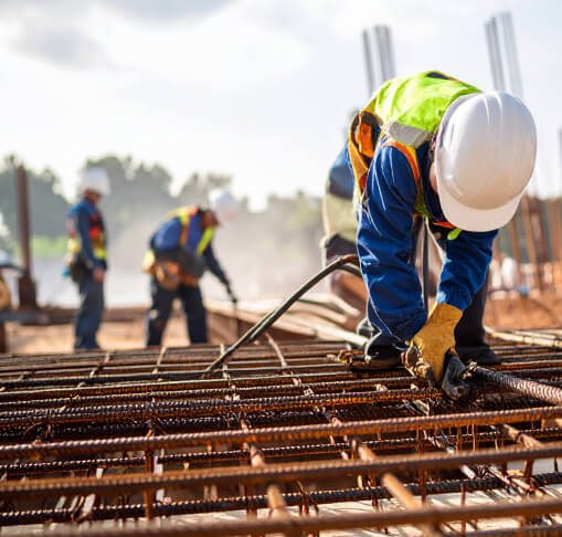 hombres trabajando sobre estructura metálica, en obra